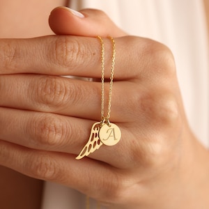 Puede incluir: Un collar de cadena dorada con un delicado dije de ala de &aacute;ngel y un dije redondo con la letra 'A' grabada.