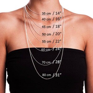 Puede incluir: Primer plano de una modelo que lleva varias cadenas de plata, cada una con una longitud diferente. Las longitudes est&aacute;n etiquetadas en cent&iacute;metros y pulgadas, que van desde 35 cm / 14" hasta 80 cm / 31".