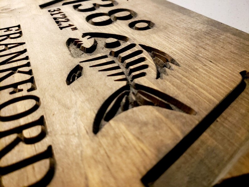 May include: A wooden sign with the text "268" and "FRANKFORD" carved into the surface. A fish silhouette is also carved into the wood.
