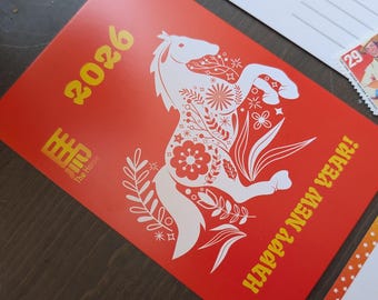 May include: A red postcard with a white horse design and the text "2026" and "HAPPY NEW YEAR!". The horse is filled with floral patterns. A USA postage stamp is visible.