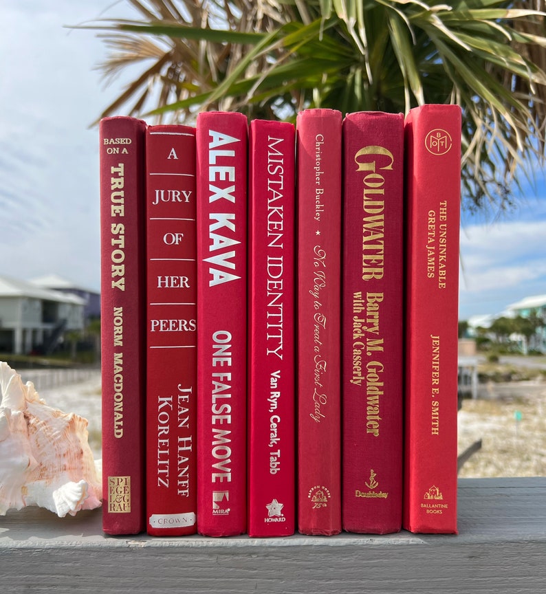 May include: A set of seven red hardcover books with gold lettering. The titles include "A Jury of Her Peers", "One False Move", "Mistaken Identity", "No Way to Treat a First Lady", "Goldwater", "The Unsinkable Greta James", and "Based on a True Story".