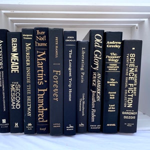 May include: A collection of black hardcover books with gold lettering on the spines. The books are arranged vertically in a white wooden crate. The titles of the books include "Old Glory", "The Passover Trilogy", "Liberating Paris", "Forever", "Martin's Hundred", "Murder Inside the Beltway", "The Second Messiah", "Ancestors", and "The Year's Best Science Fiction".