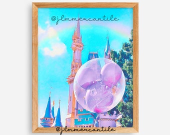 Könnte beinhalten: Ein digitales Gemälde eines rosafarbenen Mickey-Maus-Ballons vor einem blauen und grünen Schloss mit blauem Himmel und weißen Wolken. Der Text "@jlmmercantile" befindet sich oben und unten im Bild.