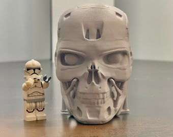 Może przedstawiać: Szara czaszka wydrukowana w 3D ze szczegółowym wzorem, obok białej figurki Lego postaci z Gwiezdnych Wojen.