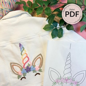 May include: White denim jacket with a colorful embroidered unicorn design. The unicorn features a rainbow horn, brown ears, and a floral crown. A digital PDF graphic is also visible.