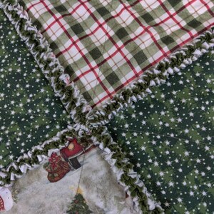 May include: A green and white plaid fabric with a white and green ruffled trim. The fabric is sewn together with a green fabric with white stars. The fabric is part of a larger quilt.