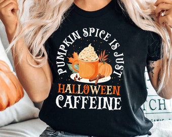 Może przedstawiać: Czarny t-shirt z jesienną grafiką. Projekt zawiera pumpkin spice latte, dynie i napis "Pumpkin Spice is Just Halloween Caffeine."