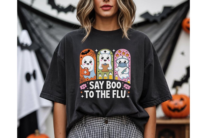 May include: Black t-shirt with a Halloween-themed graphic. The design features three cartoon ghosts dressed as a doctor, nurse, and medic, with the text "SAY BOO TO THE FLU". The ghosts are set against a backdrop of bats and pumpkins.