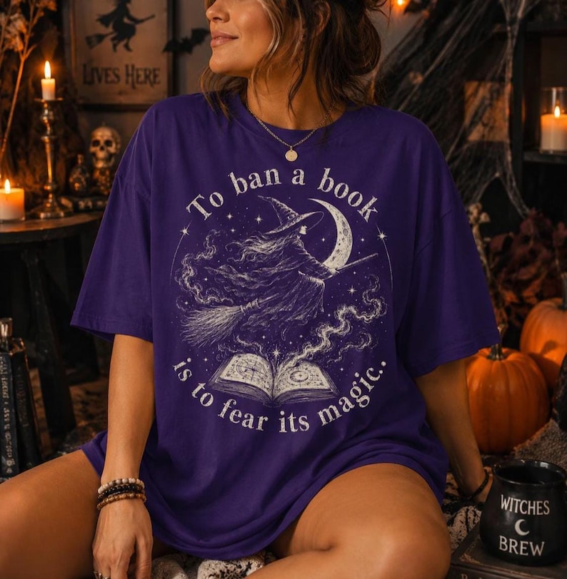 Witchy book lover Halloween shirt graphic with flying witch, moon, magical stars and open book in a distressed vintage style.