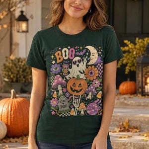 Retro Halloween collage shirt featuring a ghost in heart sunglasses, jack-o’-lantern, mushrooms and “BOO” text.