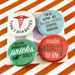 May include: Four round pinback buttons with text and graphics related to diabetes. The buttons are white, blue, green, and red. Text includes "Type 1 Diabetes", "I'm so alpha my beta cells stopped working", "Dealing with multiple pricks daily", and "insulin addict for life."