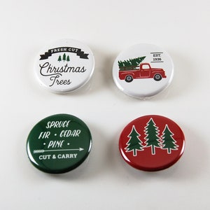 May include: Four round Christmas-themed buttons. One white button has the text "Fresh Cut Christmas Trees". Another white button features a red truck carrying a Christmas tree, with "EST. 1936". A green button says "Spruce Fir Cedar Pine Cut & Carry". A red button has three green Christmas trees.