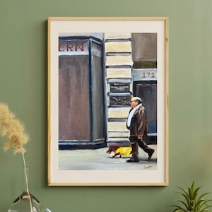 May include: A framed painting depicts a man walking a dog on a city street. The man wears a brown coat and hat, and the dog is in a yellow coat. The storefront has the word "ERN" in red letters.