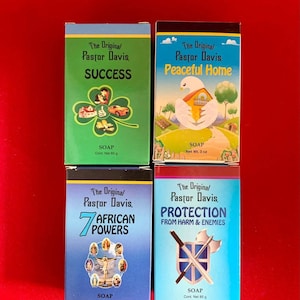May include: Four bars of soap with different themes. The first bar is green and says "The Original Pastor Davis Success". The second bar is blue and says "The Original Pastor Davis Peaceful Home". The third bar is blue and says "The Original Pastor Davis 7 African Powers". The fourth bar is blue and says "The Original Pastor Davis Protection From Harm & Enemies".