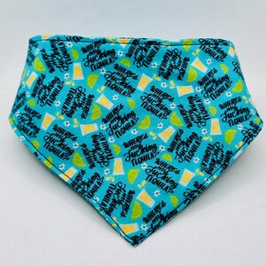 May include: A turquoise bandana with a repeating pattern of tequila glasses, lime slices, and small white flowers. The phrase "WHERE'S MY FUCKING TEQUILA?" is printed throughout the design in a bold, black font. The bandana is edged with black stitching.