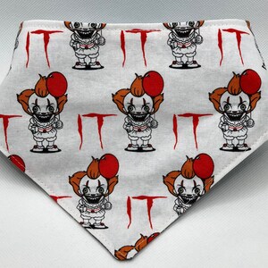 May include: White bandana with a repeating pattern of a cartoon clown holding a red balloon and the word "IT" in red.
