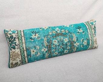 May include: A turquoise and white patterned lumbar pillow with a traditional design. The pillow is made from a soft, woven fabric.