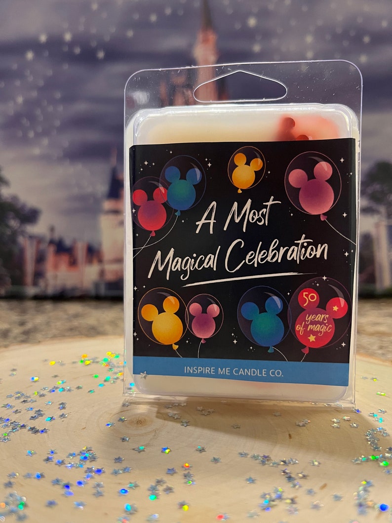 May include: A white wax melt in a clear plastic container with a black label that says "A Most Magical Celebration" with Mickey Mouse heads in colorful balloons. The label also says "50 years of magic" and "Inspire Me Candle Co."
