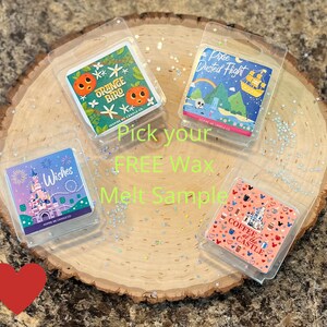 May include: Four wax melt samples displayed on a wooden surface with glitter. The wax melts are in clear plastic packaging and feature different Disney-themed designs. The designs include a castle with fireworks, a coffee cup with a castle, an orange bird, and a pixie dust flight.