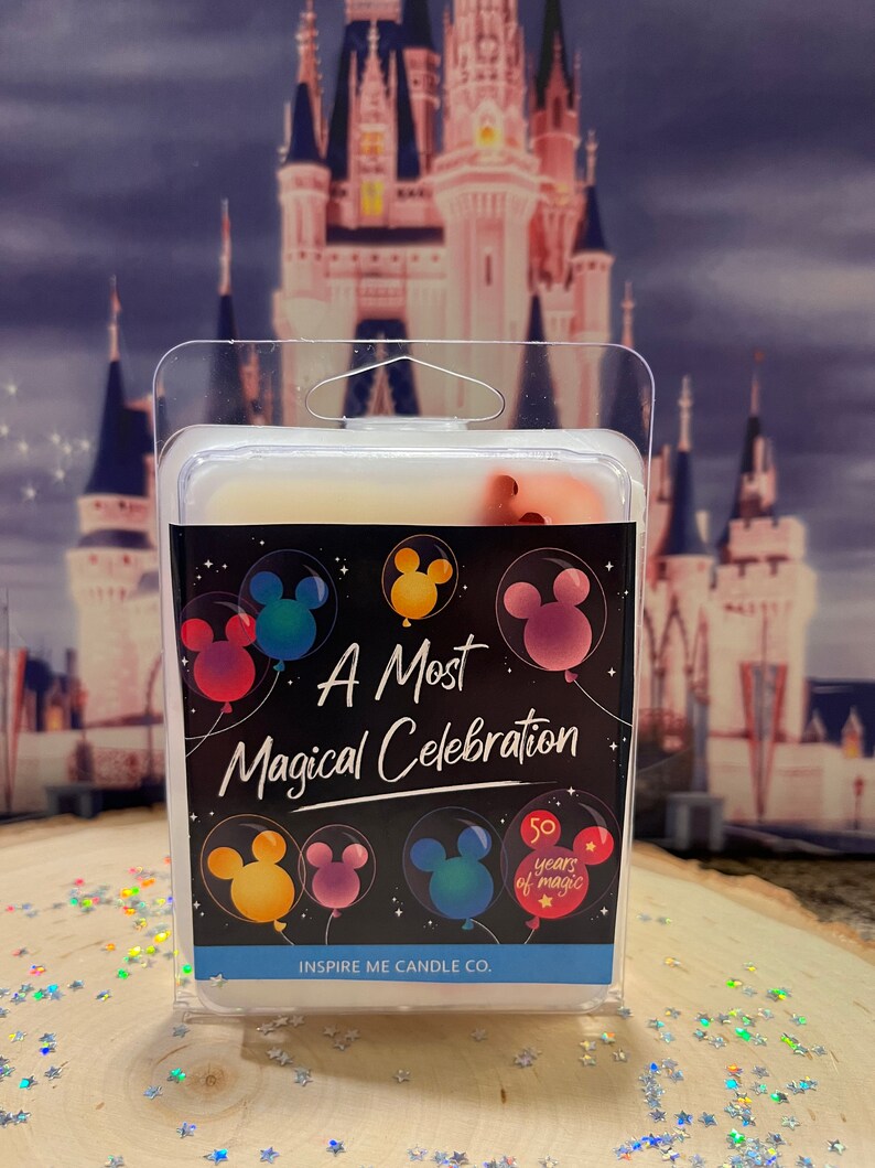 May include: A white wax melt in a clear plastic container with a black label that says "A Most Magical Celebration" with Mickey Mouse ears in balloons. The label also has a 50th anniversary logo with the text "50 years of magic". The label also says "Inspire Me Candle Co."