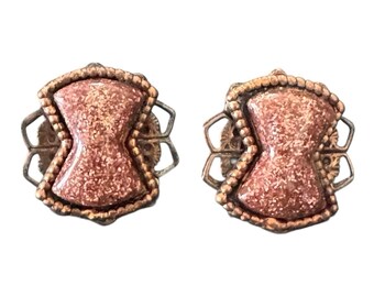 Brincos de clipe em resina acrílica com glitter dourado em tom de cobre atômico, estilo ampulheta de meados do século XX.