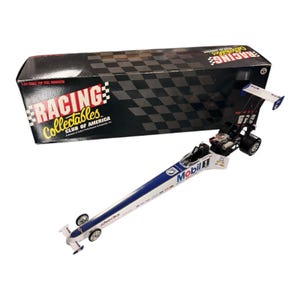 Op de afbeelding: Een 1:24 schaalmodel van een Top Fuel dragracer met een wit en blauw lichaam, met Mobil 1-branding. Het model staat naast een zwarte doos met het logo van de Racing Collectibles Club of America en een dambordpatroon.