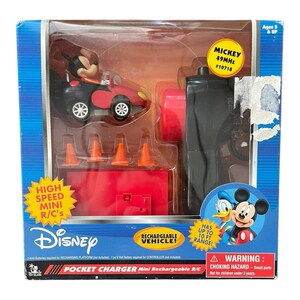 May include: A Disney Pocket Charger Mini Rechargeable R/C toy car set. The set includes a black and red race car with a Mickey Mouse figure, orange traffic cones, and a black remote control. The packaging features the text "HIGH SPEED MINI R/C's".