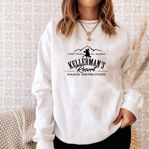May include: White sweatshirt with a black graphic of a couple dancing in front of mountains. The text reads "Kellerman's Resort Dance Instruction" and "Catskill Mountains New York State".