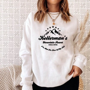 May include: White sweatshirt with a black graphic design featuring a mountain range, the text "Kellerman's Mountain Resort Catskills, NY" and the phrase "I've Had The Time Of My Life".