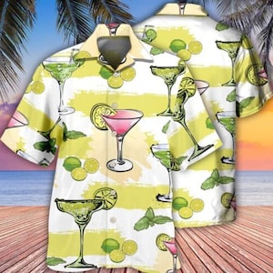 May include: A white and yellow short-sleeved button-up shirt with a tropical print featuring various cocktails and lime slices.