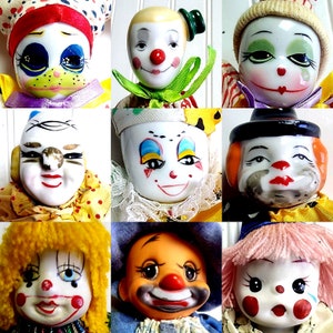 May include: Nine porcelain clown dolls with different facial expressions and colorful costumes. The dolls have painted features, including red noses, big eyes, and smiling mouths. Some dolls are wearing hats, while others have colorful hair.