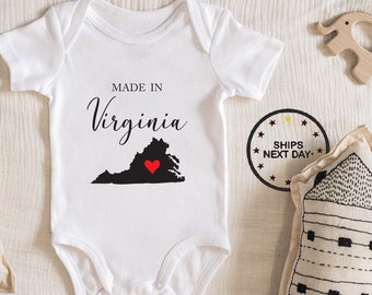May include: White baby onesie with black text that reads "Made in Virginia" and a black outline of the state of Virginia with a red heart in the center.