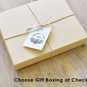 May include: A brown cardboard box with a white tag tied with twine. The tag has a black and white logo that says "Chloe's Fund".