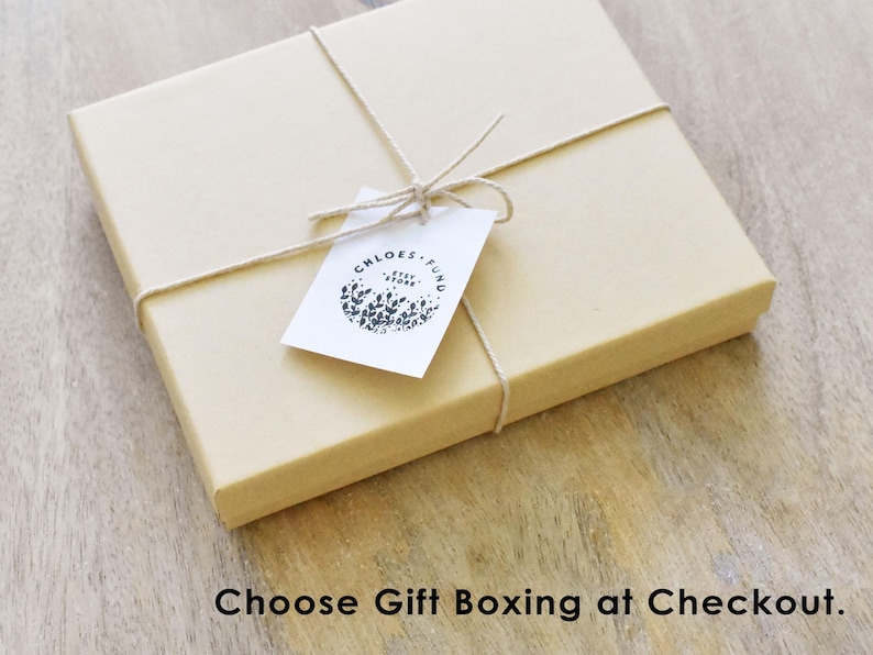 May include: A brown cardboard box with a white tag tied with twine. The tag has a black and white logo that says "Chloe's Fund".