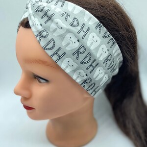 May include: A gray and white headband with a pattern of teeth and the letters "RDH".