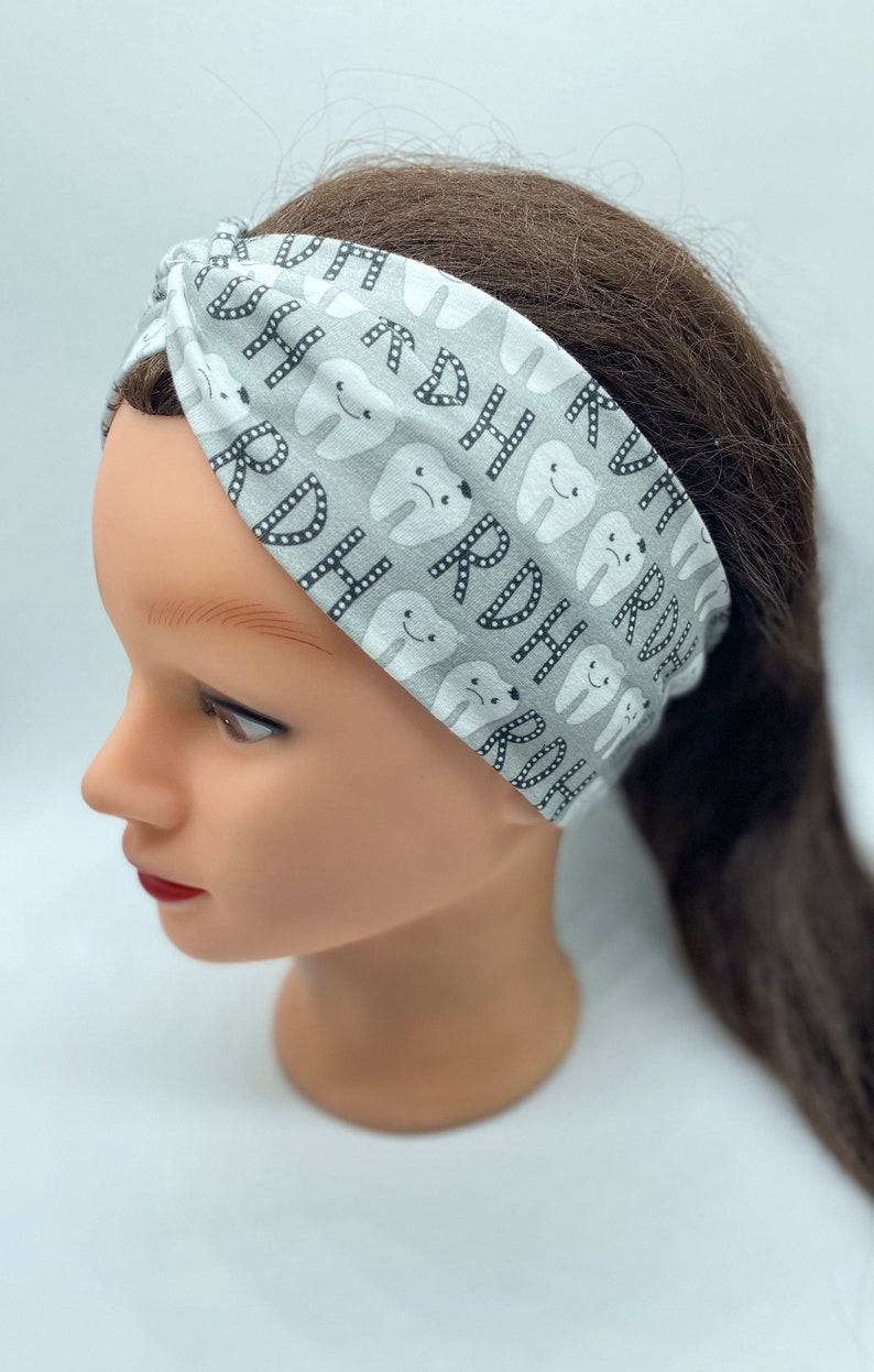 May include: A gray and white headband with a pattern of teeth and the letters "RDH".