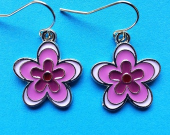 May include: A pair of silver dangle earrings with pink and white enamel flower charms. The flowers have a red center.