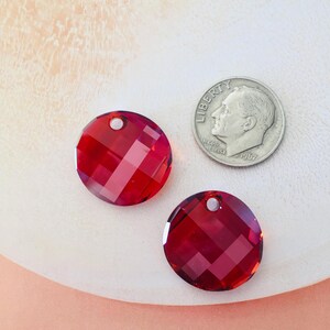 May include: Two red round crystal beads with a hole in the center. The beads are about the size of a US dime.