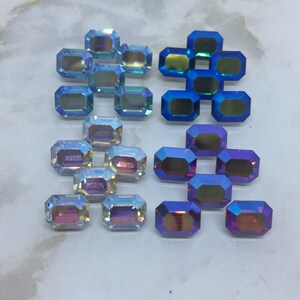 May include: Assortment of iridescent glass gems in blue, purple, and pink colors. The gems are rectangular and have a faceted design.