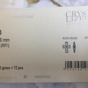 May include: A close-up of a white packaging label with black text. The label includes the product number 6860, the size 20 x 16 mm, the material Crystal (001), the quantity 00/06/00 gross = 72 pcs, and the brand name Swarovski. The label also includes a barcode and two small black and white illustrations of crystal shapes.