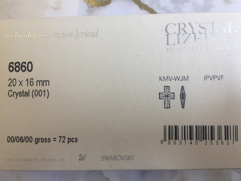 May include: A close-up of a white packaging label with black text. The label includes the product number 6860, the size 20 x 16 mm, the material Crystal (001), the quantity 00/06/00 gross = 72 pcs, and the brand name Swarovski. The label also includes a barcode and two small black and white illustrations of crystal shapes.