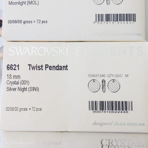 May include: Three boxes of Swarovski Elements Twist Pendant crystals. Each box features a different color crystal: Moonlight, Silver Night, and Silver Shade. The boxes include the product number, size, color, and quantity.