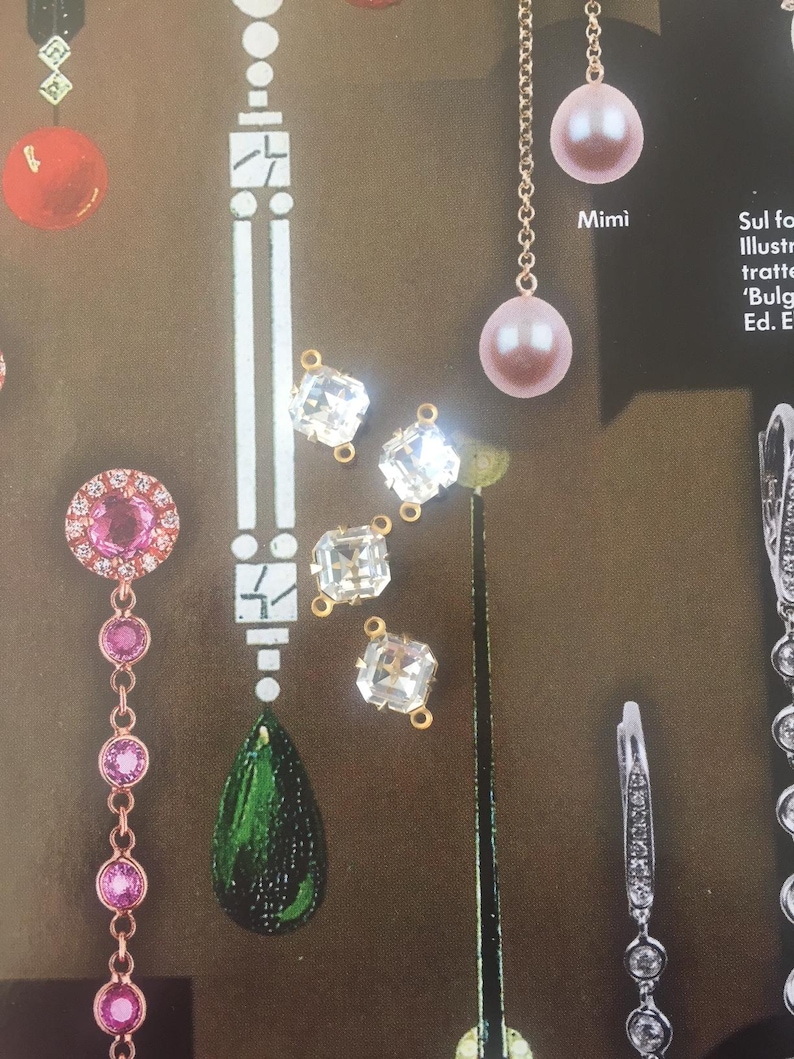 May include: An assortment of jewelry pieces, including earrings and pendants, are displayed against a brown background. The earrings feature pink pearls, clear crystals, and green teardrop-shaped stones. The word "Mimi" is visible.