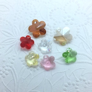 Peut inclure: Assortiment de breloques en cristal en forme de fleurs colorées. Les breloques sont dans des tons de rouge, orange, jaune, vert et rose. Elles sont parfaites pour ajouter une touche d'éclat à vos bijoux ou à vos créations.