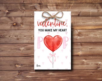 May include: Valentine's Day card with a red heart lollipop and the text "valentine, you make my heart pop. love."