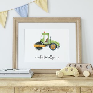 Op de afbeelding: Een aquarel-illustratie van een groen bouwvoertuig met de tekst "be friendly" eronder. De illustratie is ingelijst in een licht houten lijst en wordt tentoongesteld op een plank met een houten speelgoedauto.