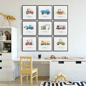 Op de afbeelding: Negen ingelijste aquarel illustraties van bouwvoertuigen met motiverende zinnen zoals "wees gelukkig", "wees sterk" en "droom groot".
