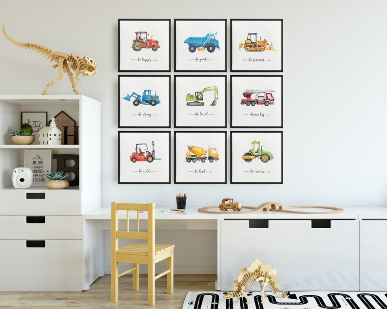 Op de afbeelding: Negen ingelijste aquarel illustraties van bouwvoertuigen met motiverende zinnen zoals "wees gelukkig", "wees sterk" en "droom groot".