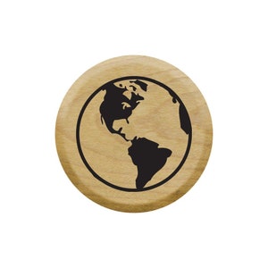 May include: A round wooden stamp with a black silhouette of the Earth on it.