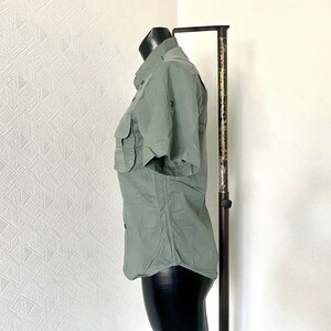 Pu&ograve; includere: Una camicia a maniche corte di colore verde chiaro con bottoni e una tasca sul petto sinistro. La camicia &egrave; su un manichino e ha una vestibilit&agrave; rilassata.